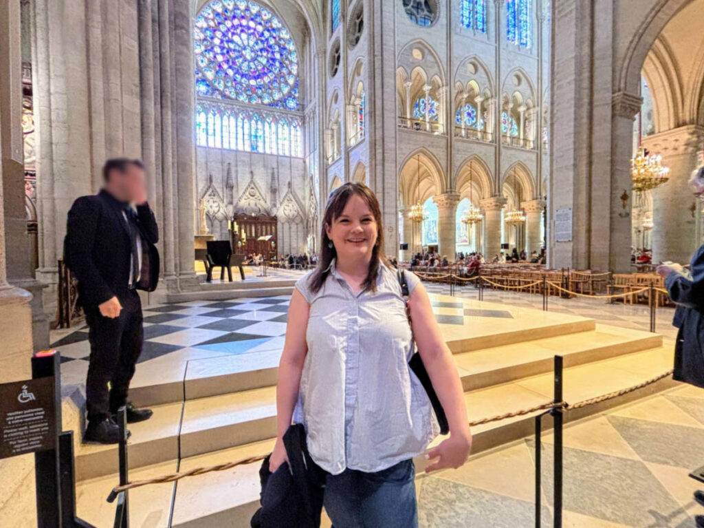 The author Rachel Kapelke-Dale posing for a photo inside the Notre Dame Cathedral