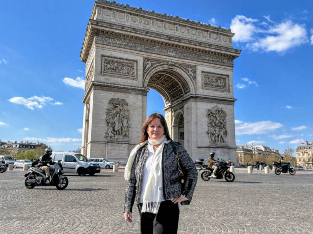 The author Rachel posing for a photo in front of the Arc de Triomphe