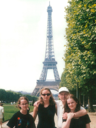 The author Rachel and her family, posing for a photo in front of the Eiffel Tower
