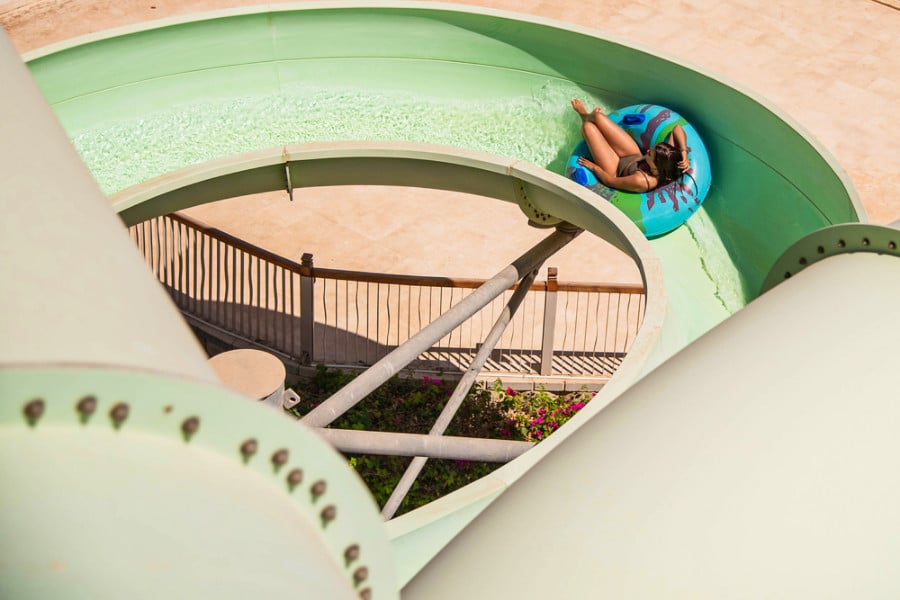 A girl riding on the water slide on a sunny day