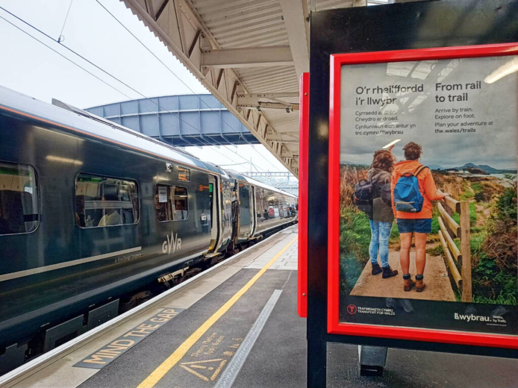 A rail to trail advertisement on a train station in Wales