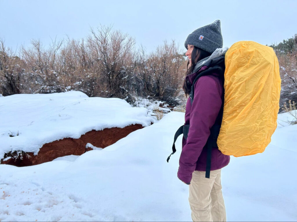 The author, Abigail, tested the backpack with a rain cover on a winter day