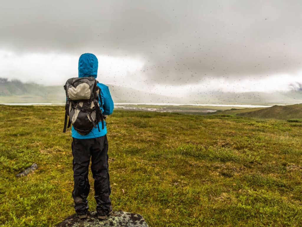 A man wearing a rain jacket during his hike in Alaska