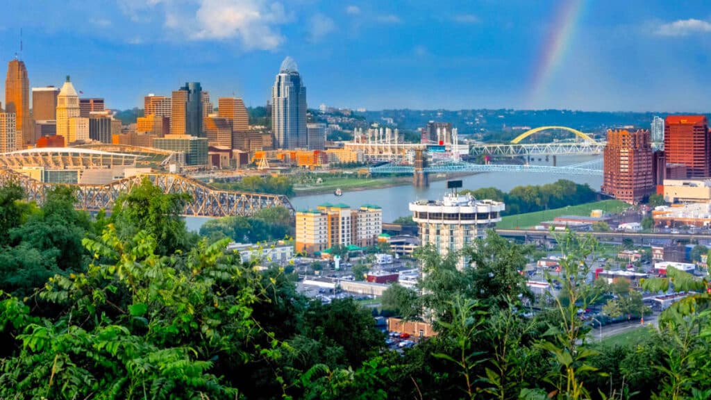 View of the golden Cincinnati skyline with rainbow during sunset