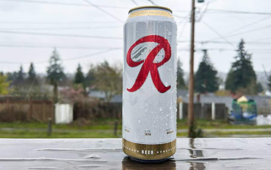A cold can of Rainier Beer with a gloomy sky in the background