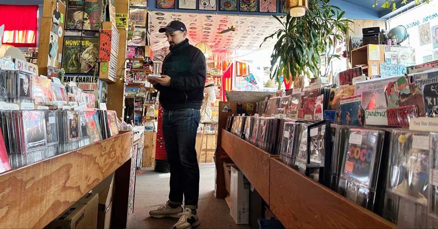 The author's husband browsing some cassette tapes inside Rainy Day Records