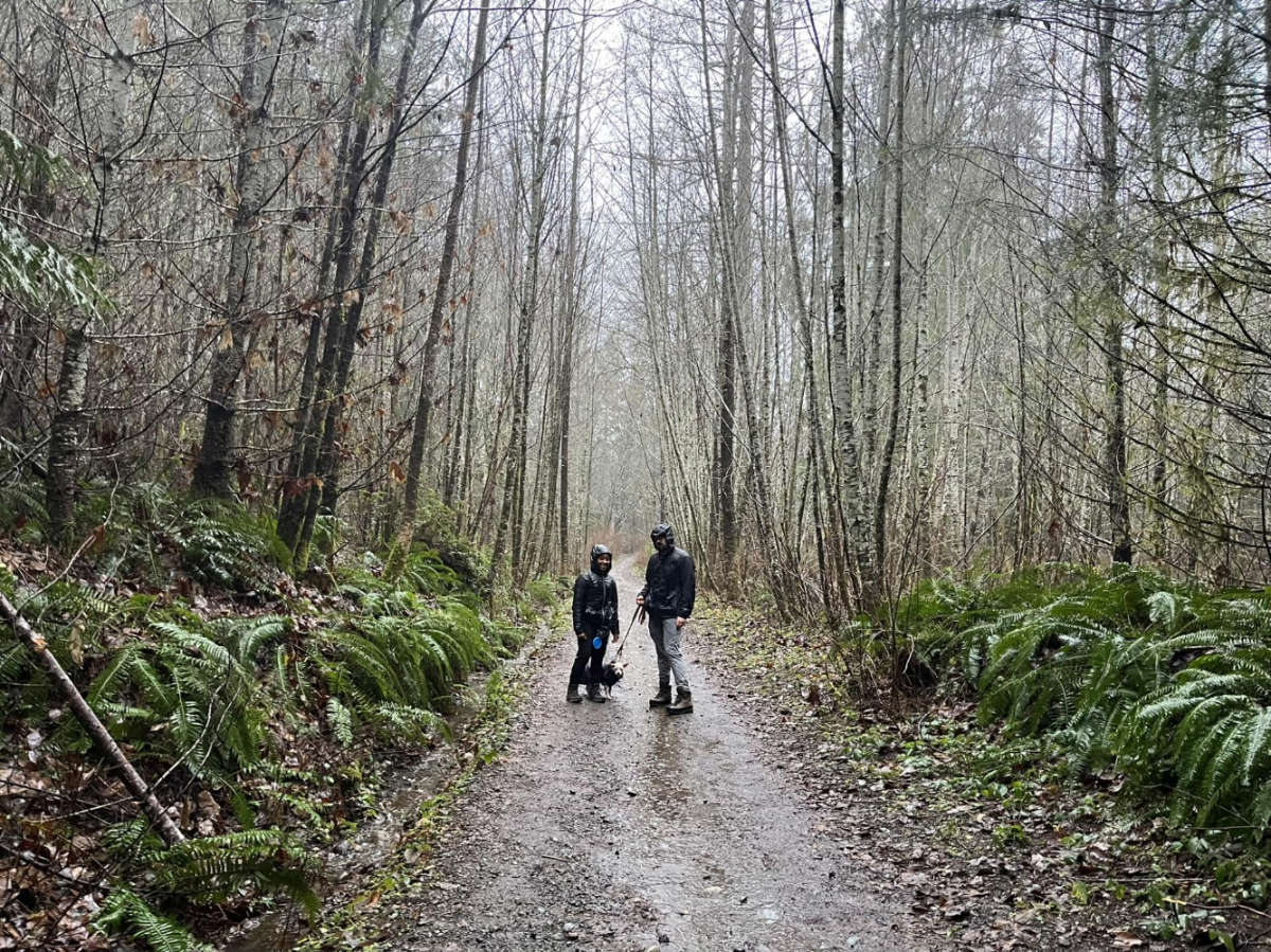 Chelsea Booker with her husband and dog during a rainy winter hike