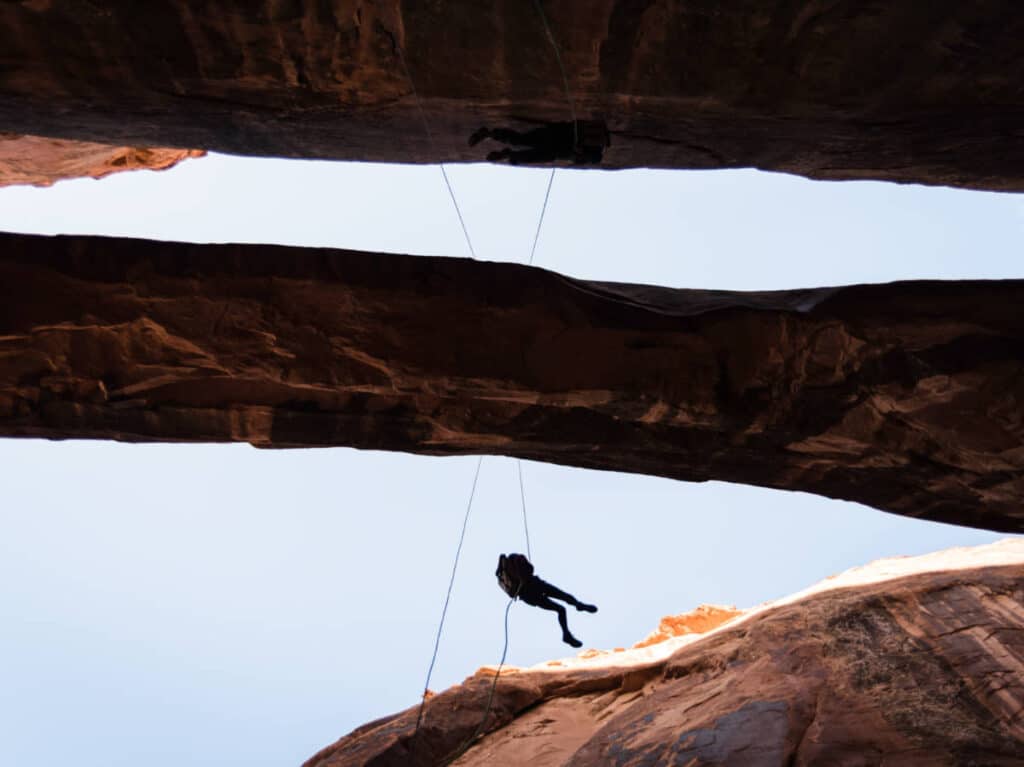 A woman rappelling on the huge rock formations