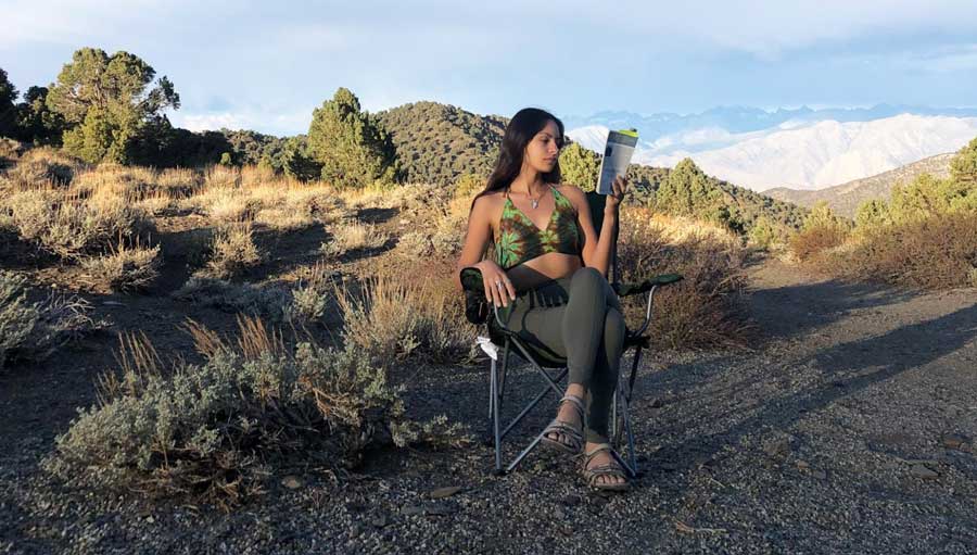 The author reading a book during her break on a road trip in California backcountry