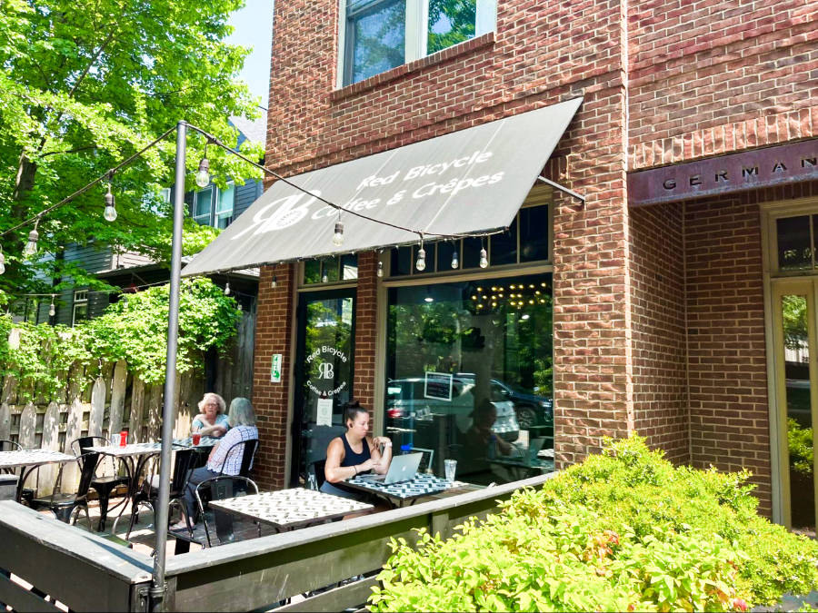View of people enjoying the outdoor dining area of Red Bicycle Coffee and Crepes in Germantown