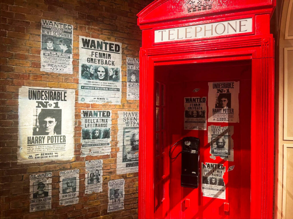 View of the wanted Harry Potter posters and the red telephone booth inside the Harry Potter Store