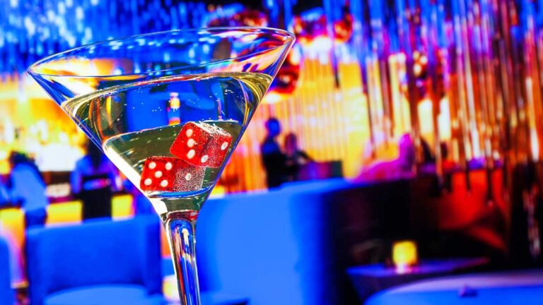 A red dice on a cocktail glass in a bar