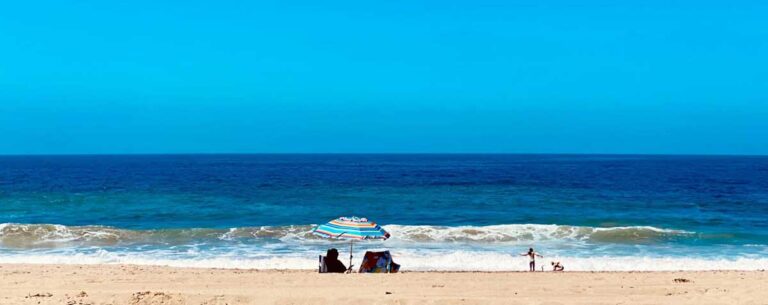 People enjoying the blue water under the clear blue sky in Malibu