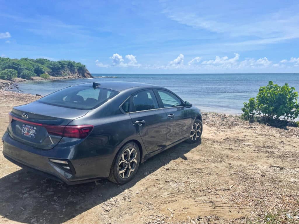 A car parked near a beach under the blue sky