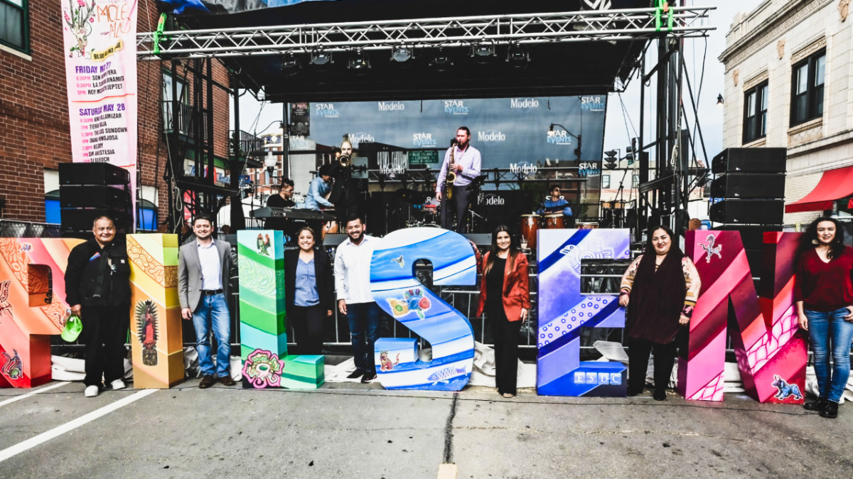 View of the residents posing at the Pilsen signage