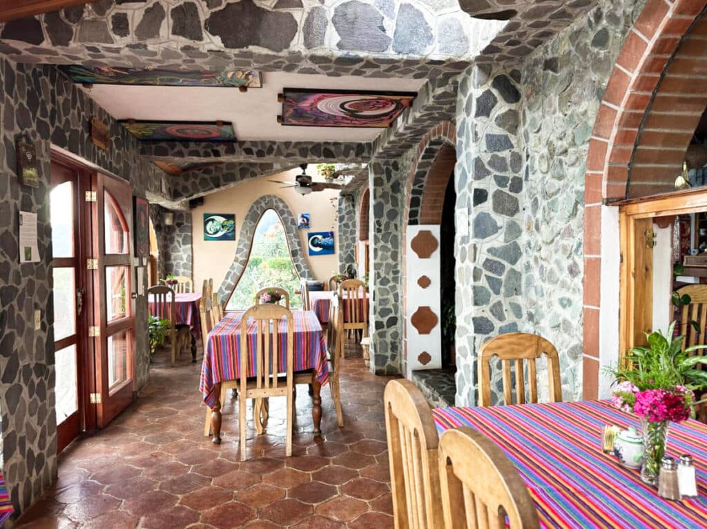 View of the stone walled and colorful textiles inside the restaurant of La Casa del Mundo