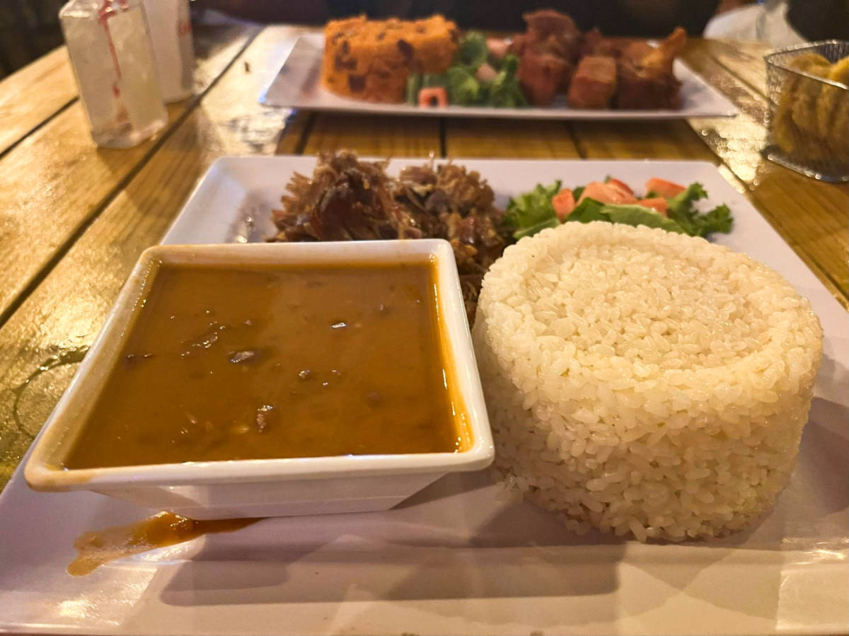 A plate with a cup of rice and bean soup