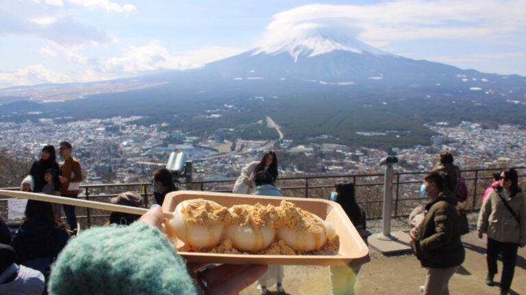 Travel Lemming writer Sky Ariella with rice cakes at a Mount Fuji viewpoint
