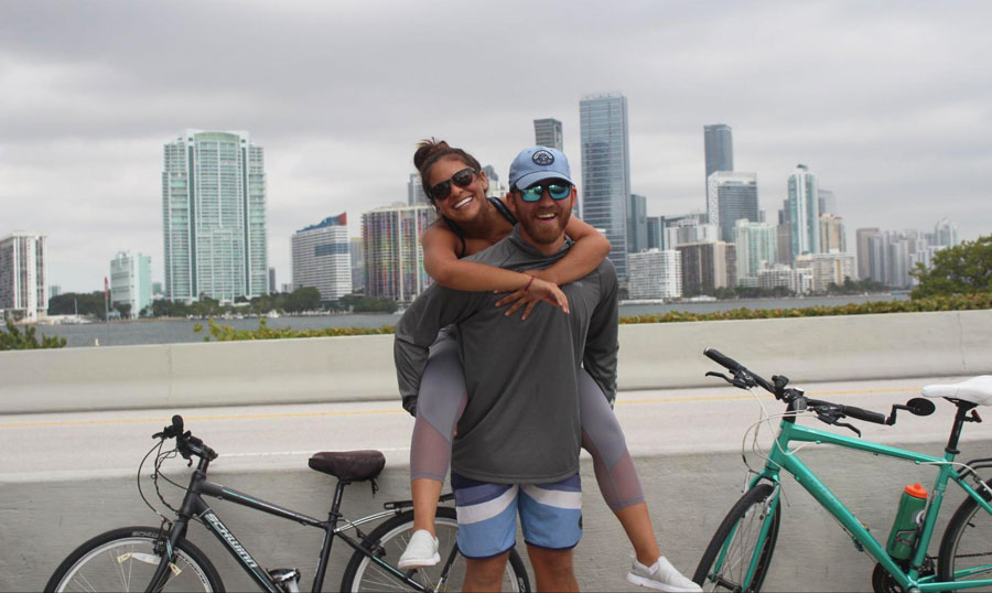 The author and her wife posing for a picture in William Powell Bridge with their bike on their background