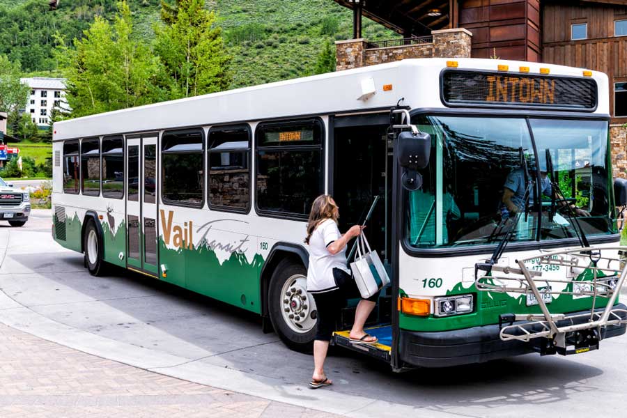 A woman riding a bus on a town in Vail