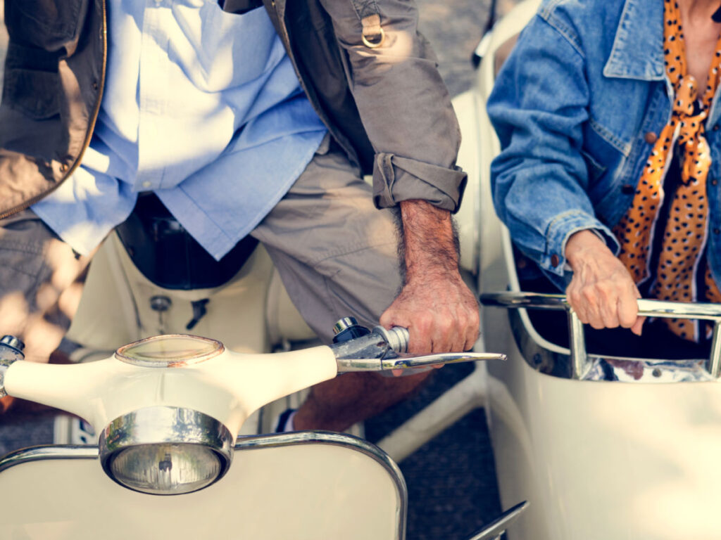 Senior couple riding a classic scooter