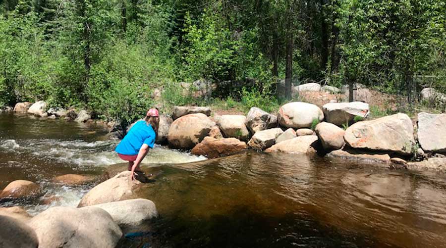 A woman crossing a river in Rio Grande Trail