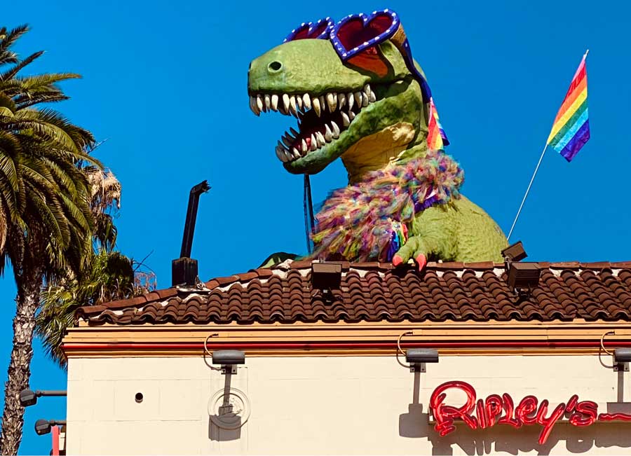 A dinosaur with rainbow flag on the roof of Ripley’s Believe It or Not