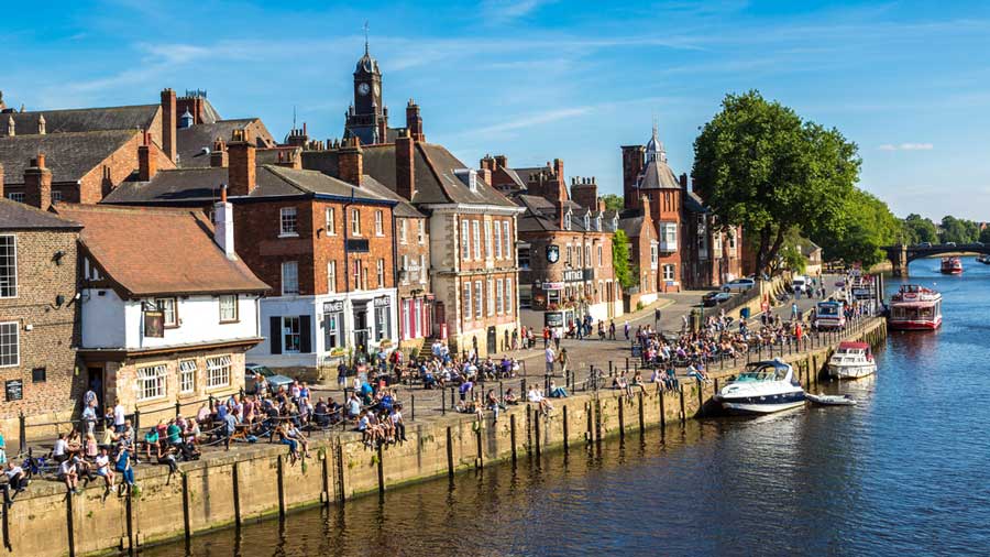 People relaxing on the side of the River Ouse