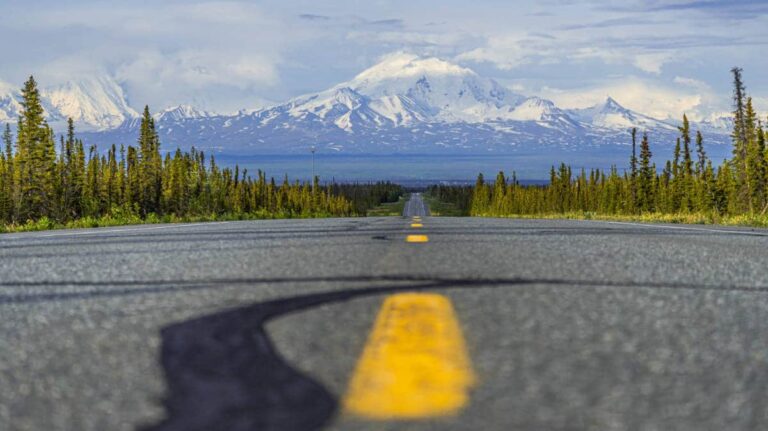 A road winding through a landscape with mountains rising in the background