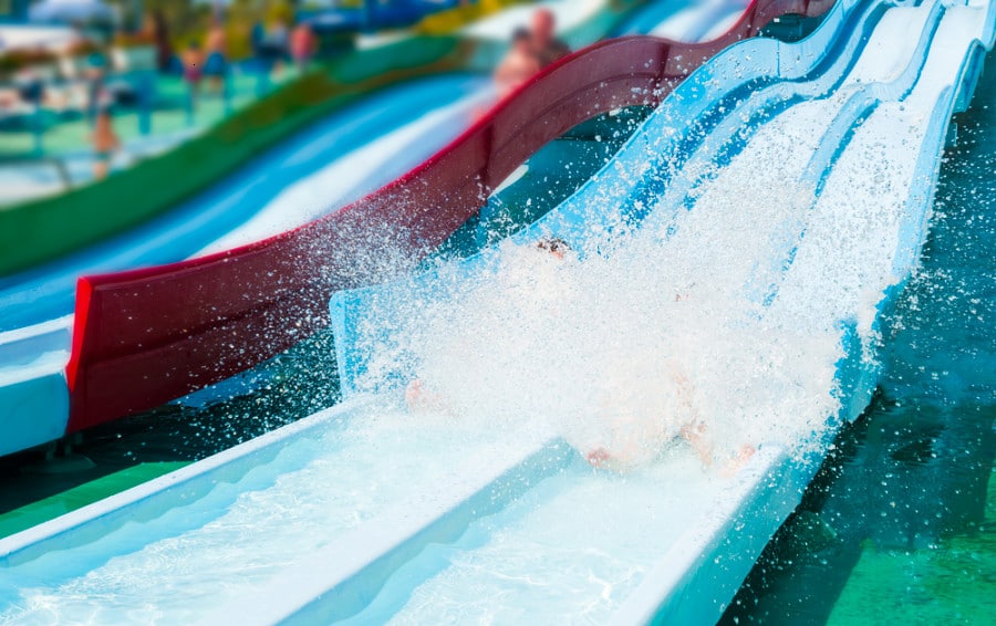 People splashing while sliding down on a water slide