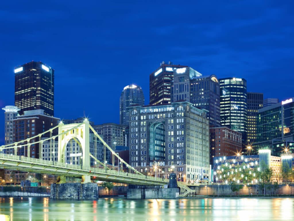 The Roberto Clemente Bridge and buildings with lights at night in Pittsburgh