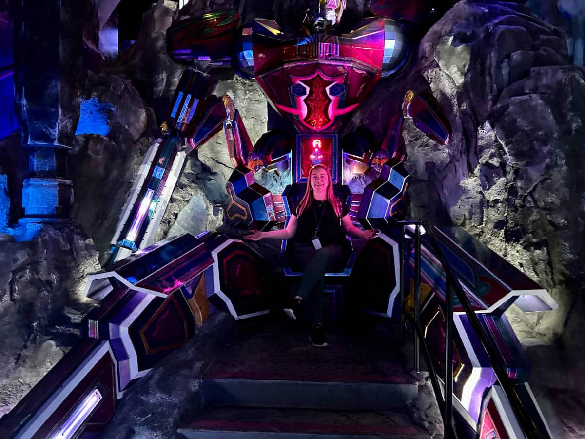 The author, Laura Falin sitting on a robotic themed chair at Meow Wolf Convergence Station