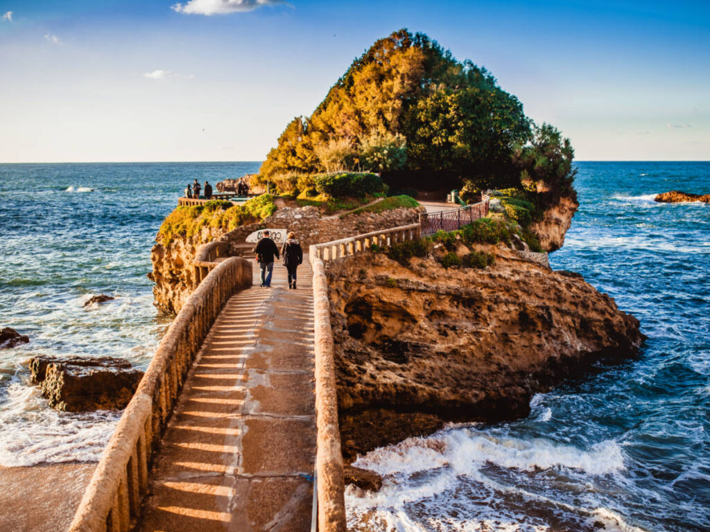 View of the people on the walkway at Rocher de la Vierge over the beach