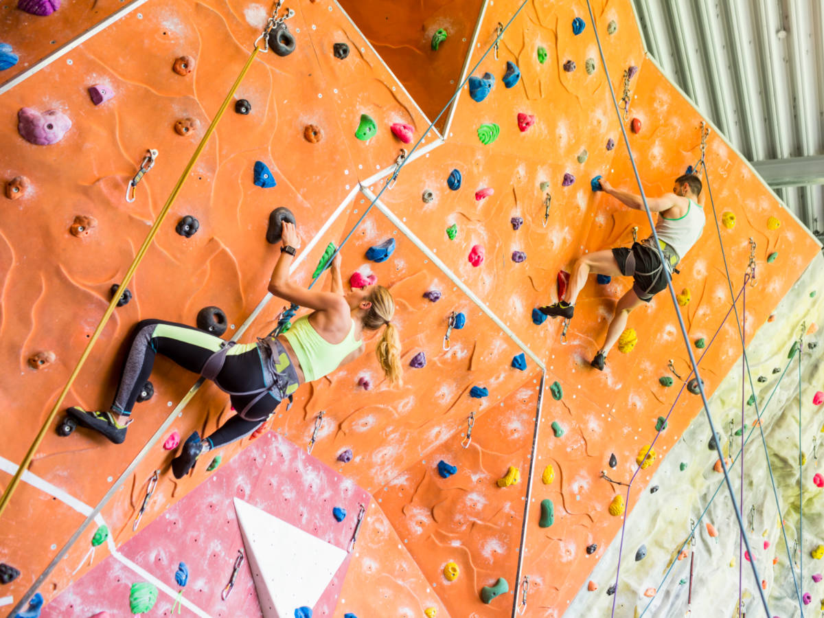Fit couple rock climbing indoors