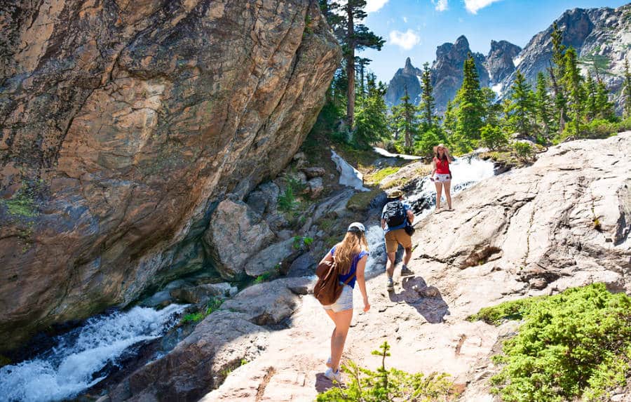 People hiking on the rocky mountains with a little stream in Colorado