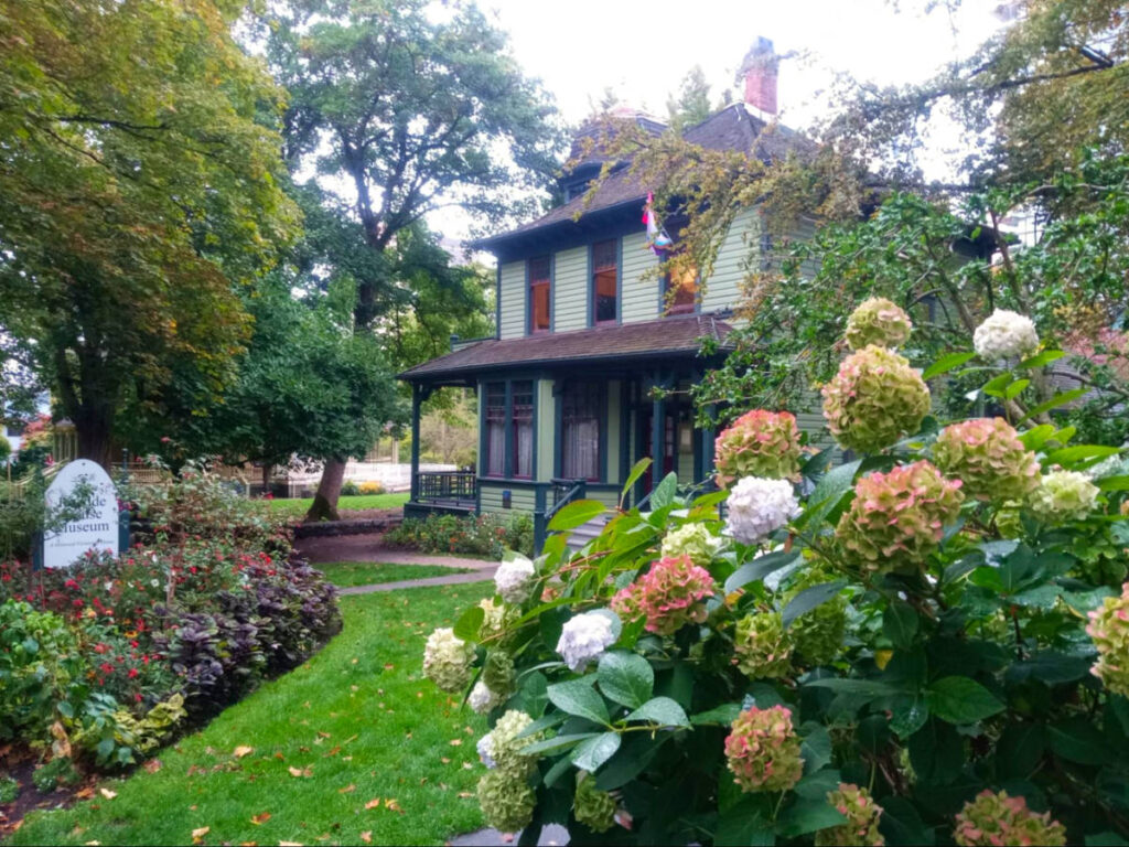 Outside view of Roedde House Museum with a well-maintained garden and a variety of colorful flowers