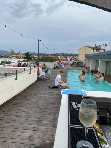 People enjoying their day on a rooftop pool in a hostel