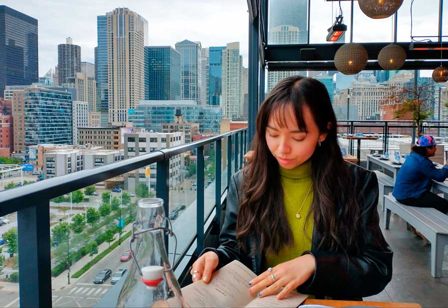 The author looking at the menu on the rooftop of bar avec