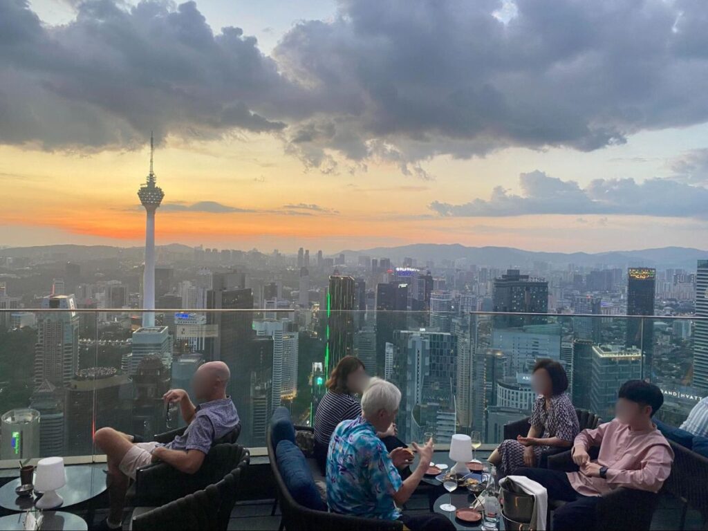 People enjoying cocktails at a Rooftop bar overlooking KL