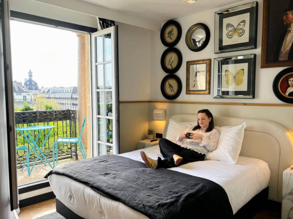 The author Rachel Kapelke-Dale sitting on her room at the Solly Hôtel Paris