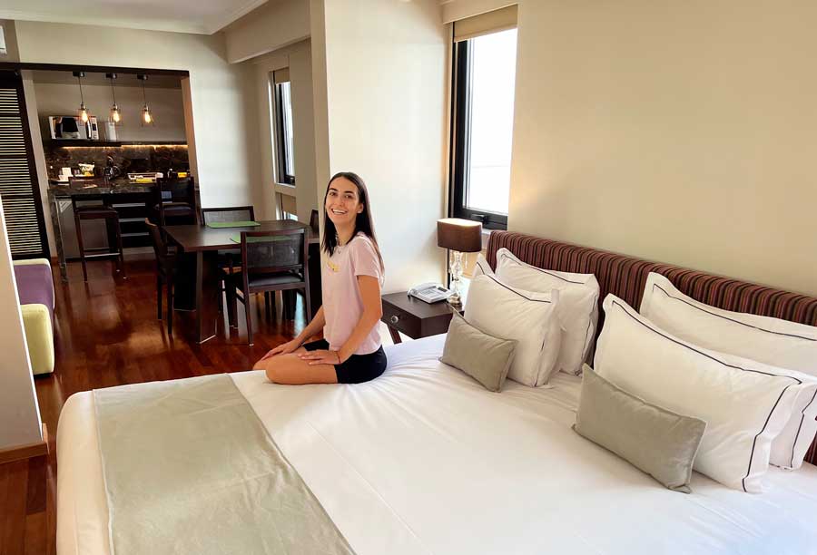 Clara sitting on a bed inside a room in Esplendor by Wyndham Buenos Aires Tango