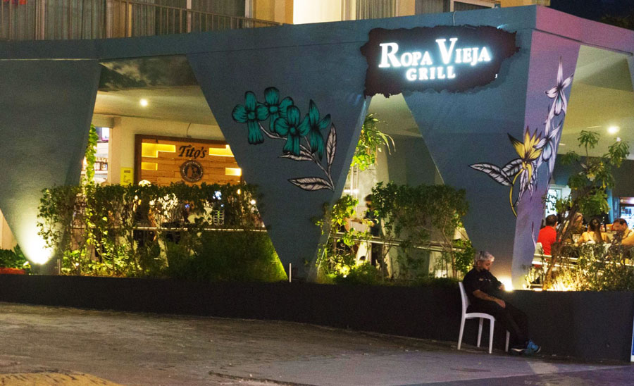 The Ropa Vieja Grill sign illuminated with lights at night