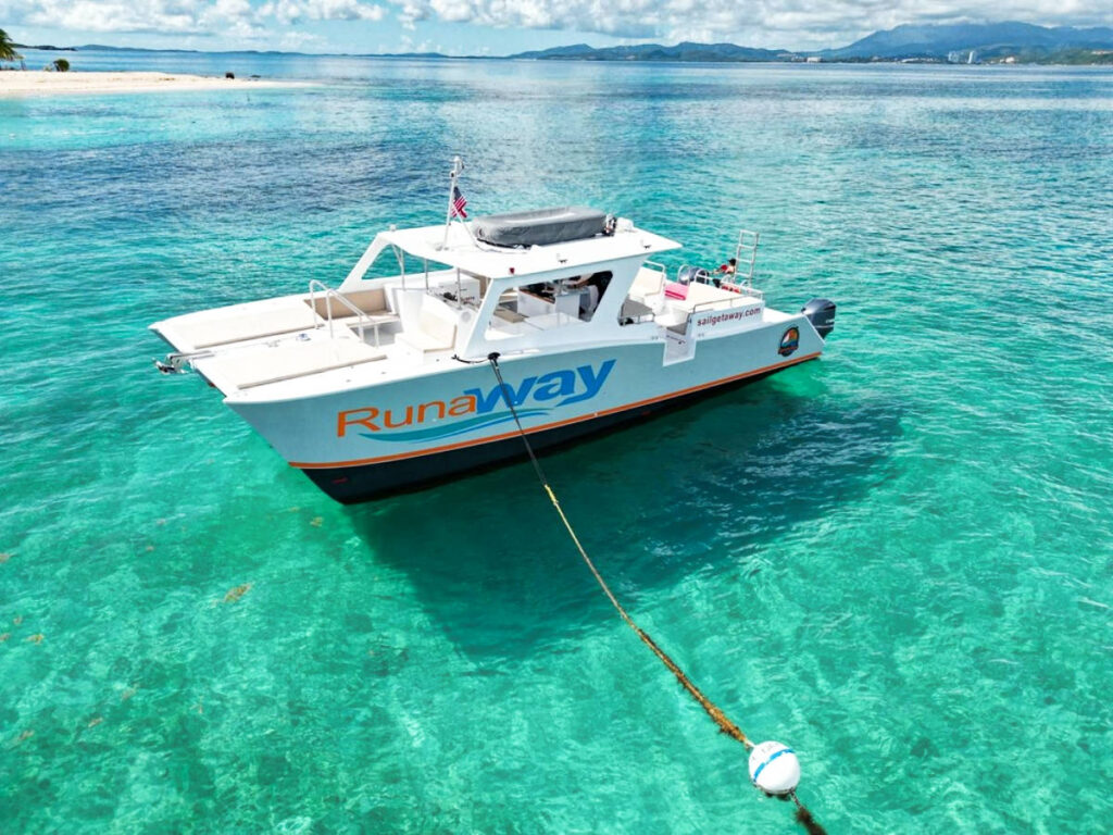 The white catamaran docked on the azure water