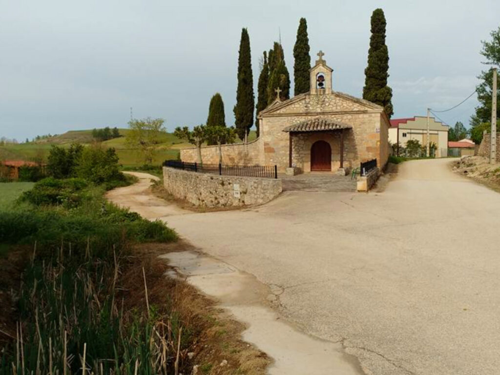 Paved road winding through a rural "pueblo" in Camino