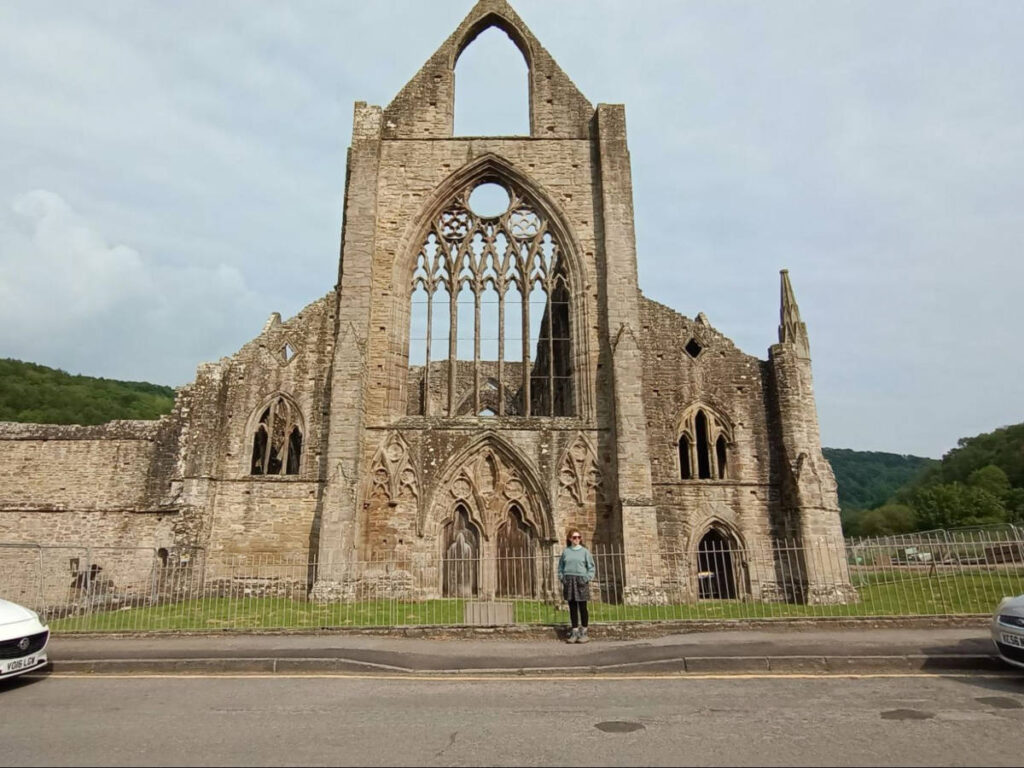 The author Ruthie, posing for a photo in front of the Tintern Abbey