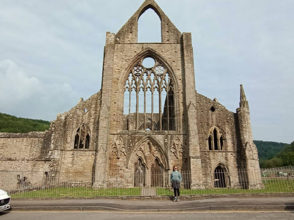 The author Ruthie posing for a photo in front of the Tintern Abbey