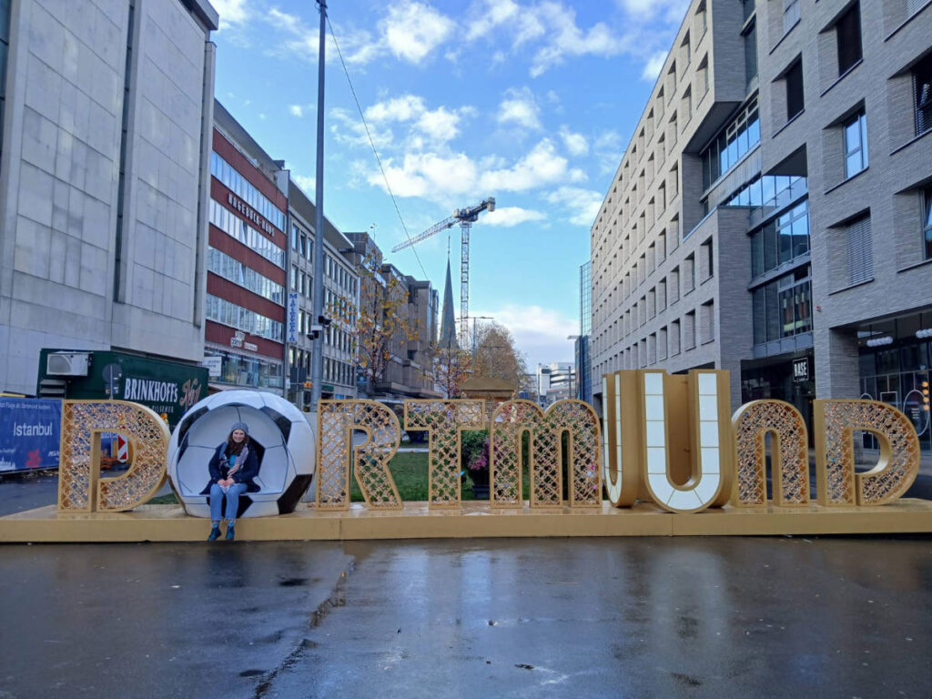 The author Ruthie taking a photo on the signage of Dortmund