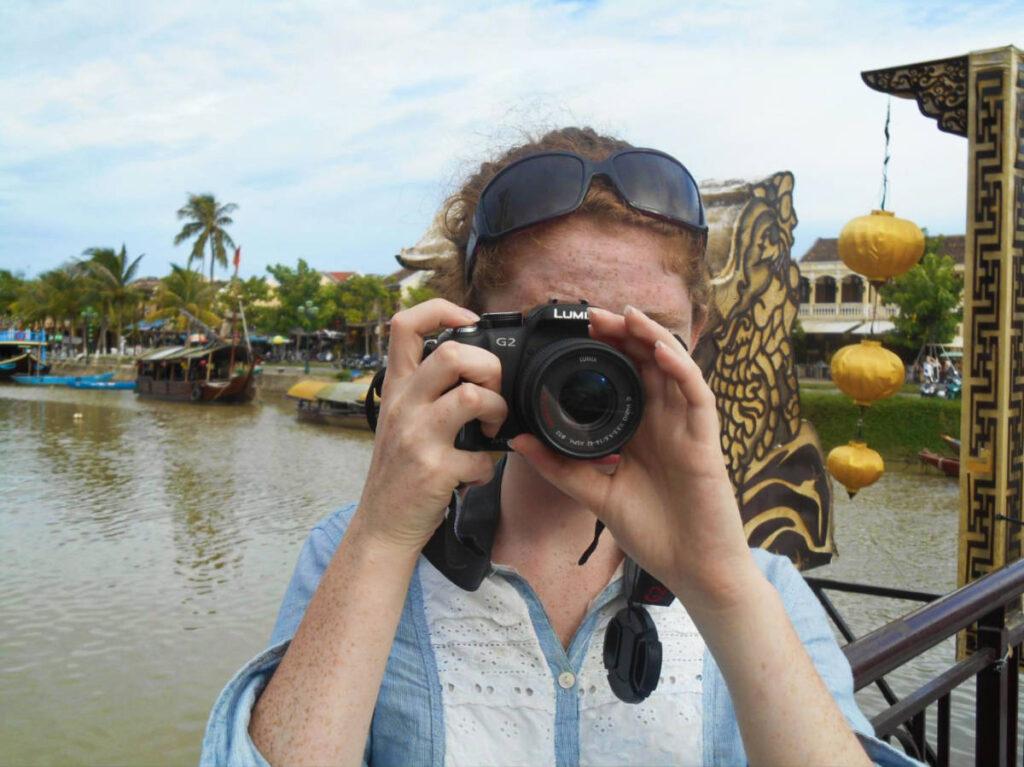 The author Ruthie Walters, taking a photo with her DSLR in Hoi An, Vietnam