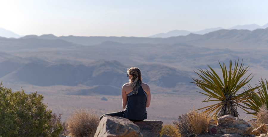 View of a woman admiring her view from top of the Ryan Mountain Trail