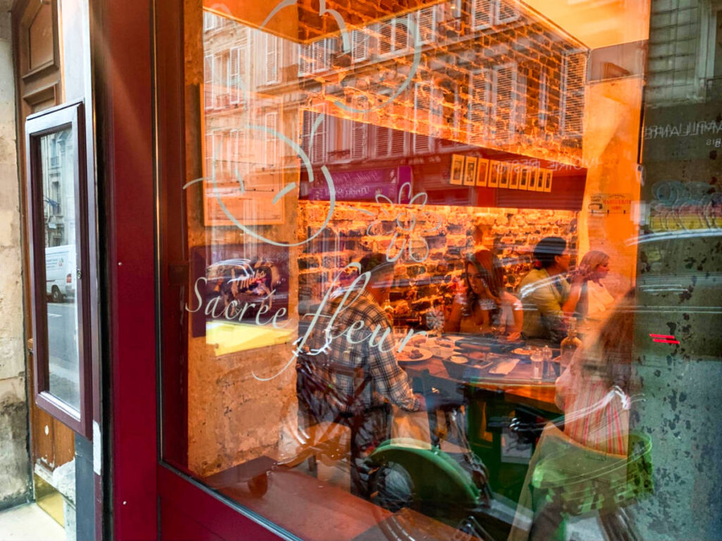 View of the diners from the glass window outside of Sacrée Fleur